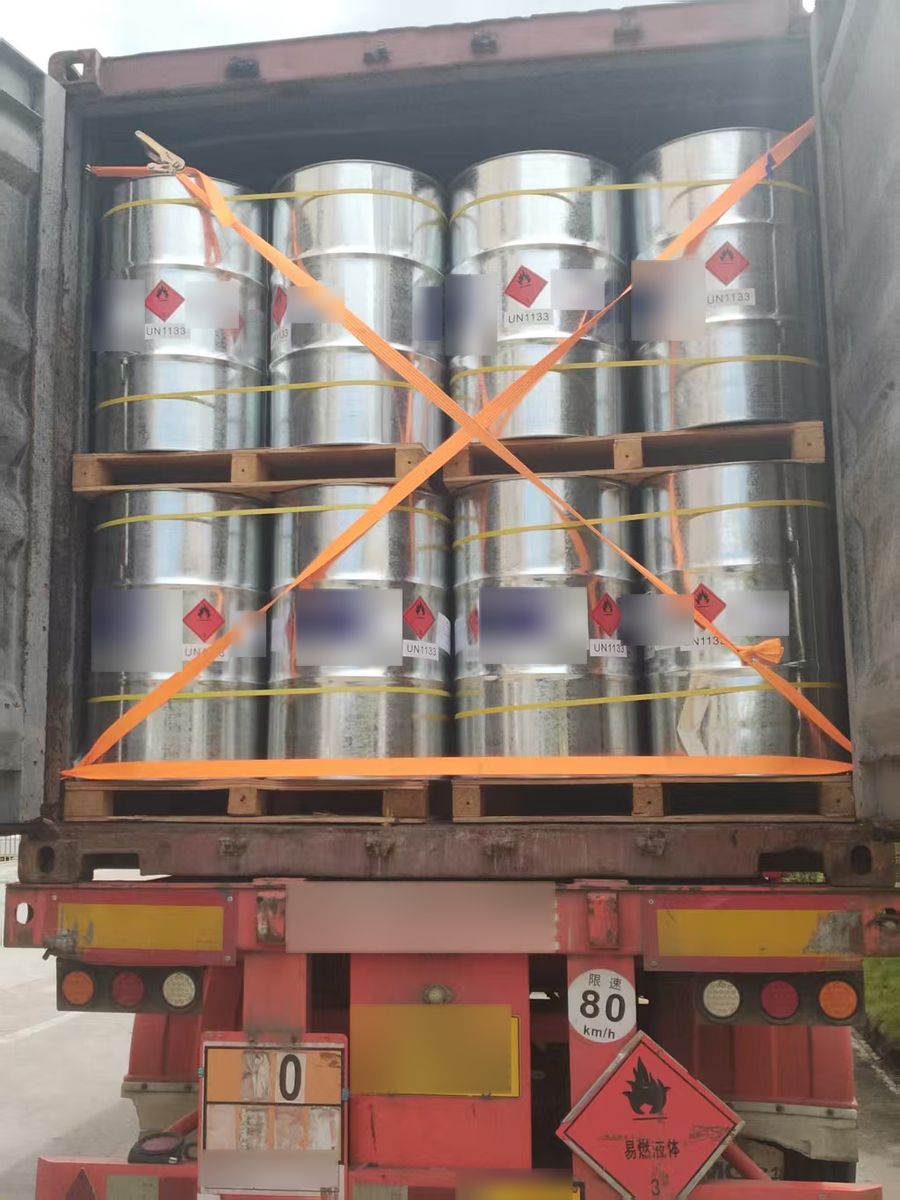 Steel drums with dangerous-goods labels strapped inside a container