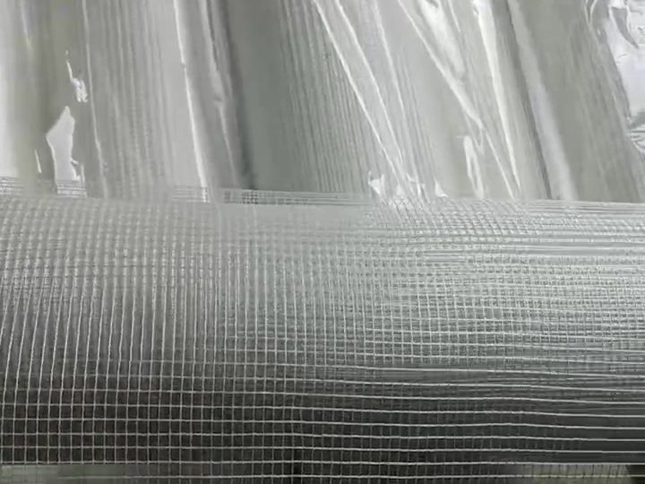 Fiberglass mesh cloth unrolled over a stack of rolls